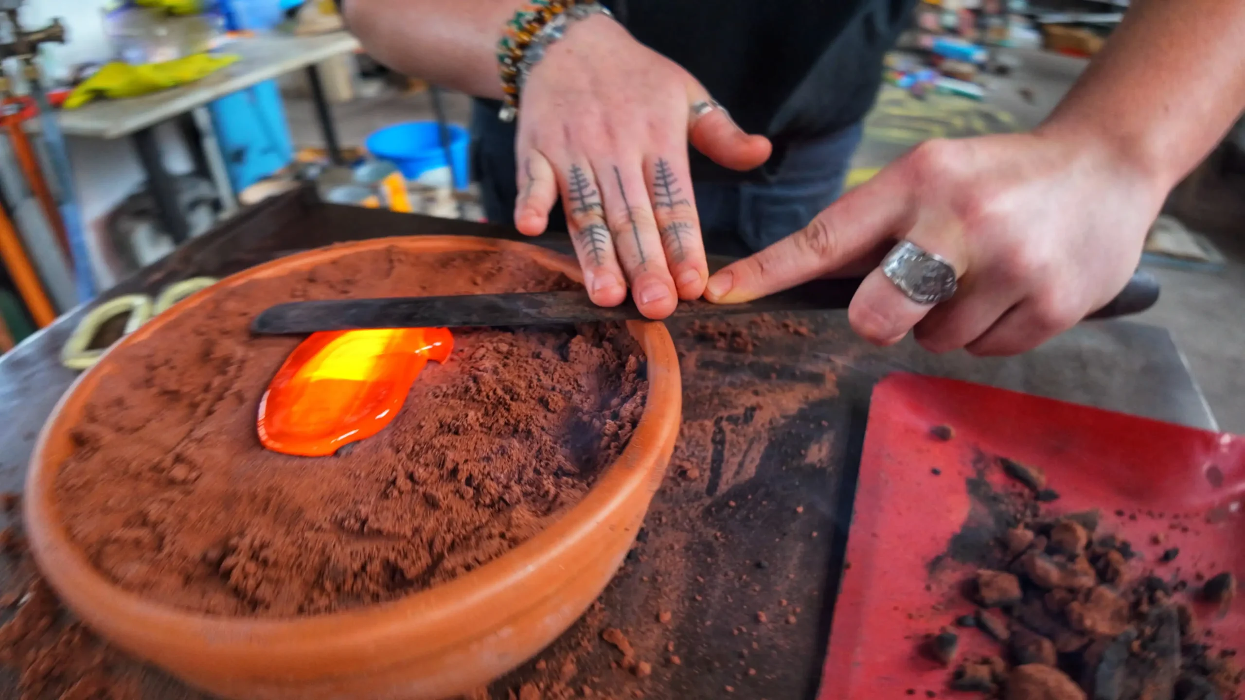 Pendant la coulée, Léa accompagne la mise en place du verre en fusion dans le moule afin d'assurer une répartition homogène de la matière.