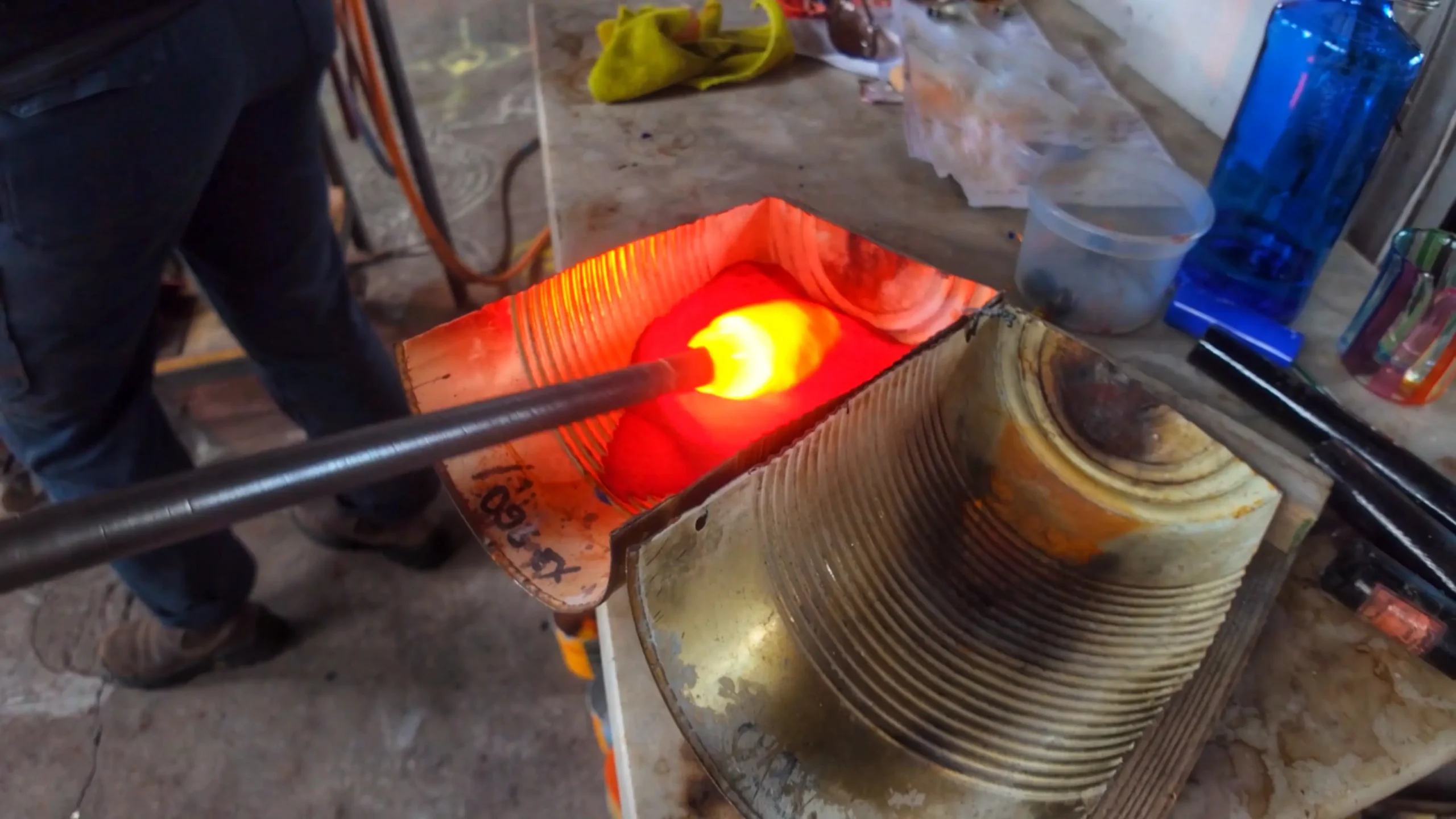 Après avoir cueilli le verre en fusion, Pierrot Dorémus le fait rouler dans une poudre de verre colorée. Sous l'effet de la chaleur, les particules se fixent à la surface et fusionnent avec la masse de verre. Cette étape permet d'apporter la couleur souhaitée à la pièce finale tout en conservant la transparence et la profondeur caractéristiques du verre soufflé.
